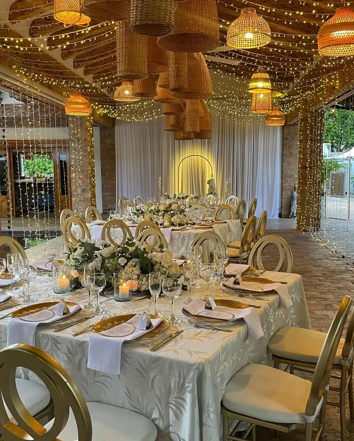 Salón con lámparas de mimbre y mesas doradas